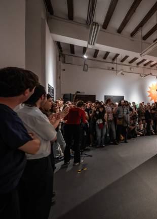 Públic dempeus en un espai expositiu durant una acció del Parlamalament.